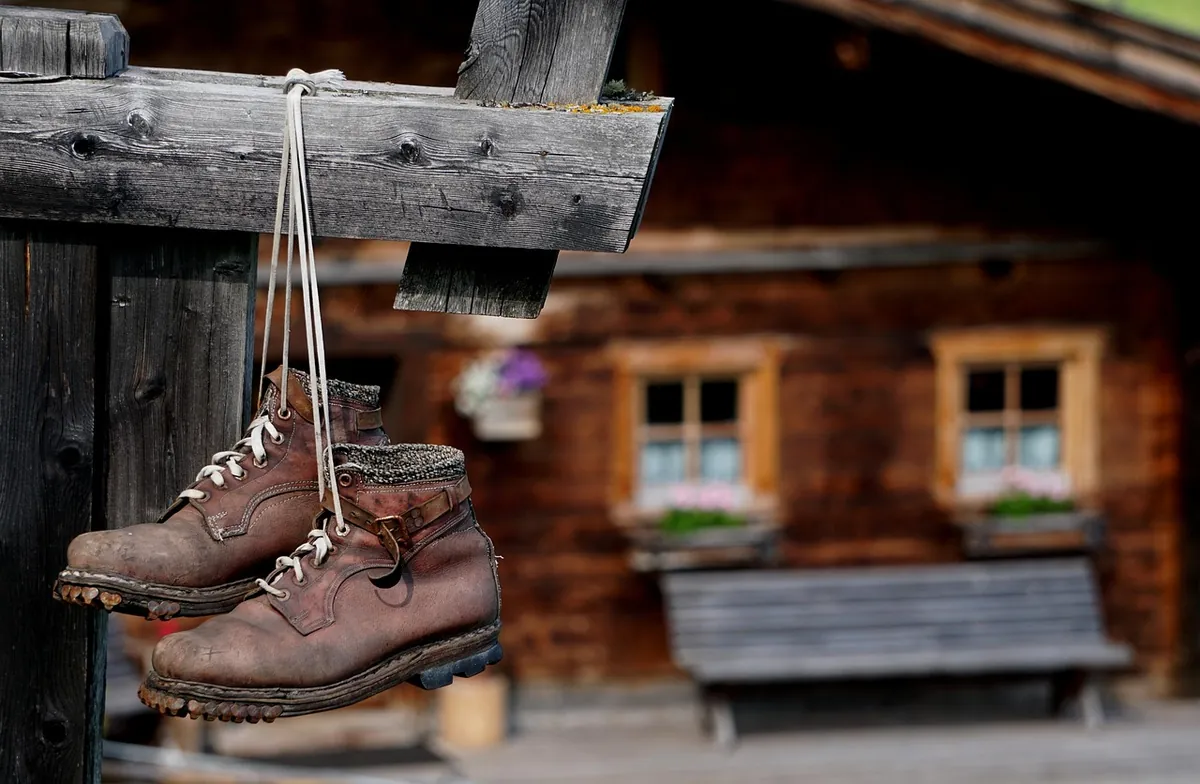Bergschuhe hängen vor einer Almhütte